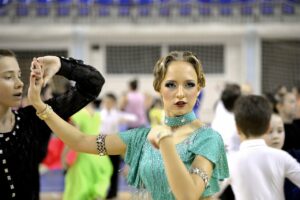 A young man turning a female Latin ballroom dancer during Latin Ballroom Dance Lessons.