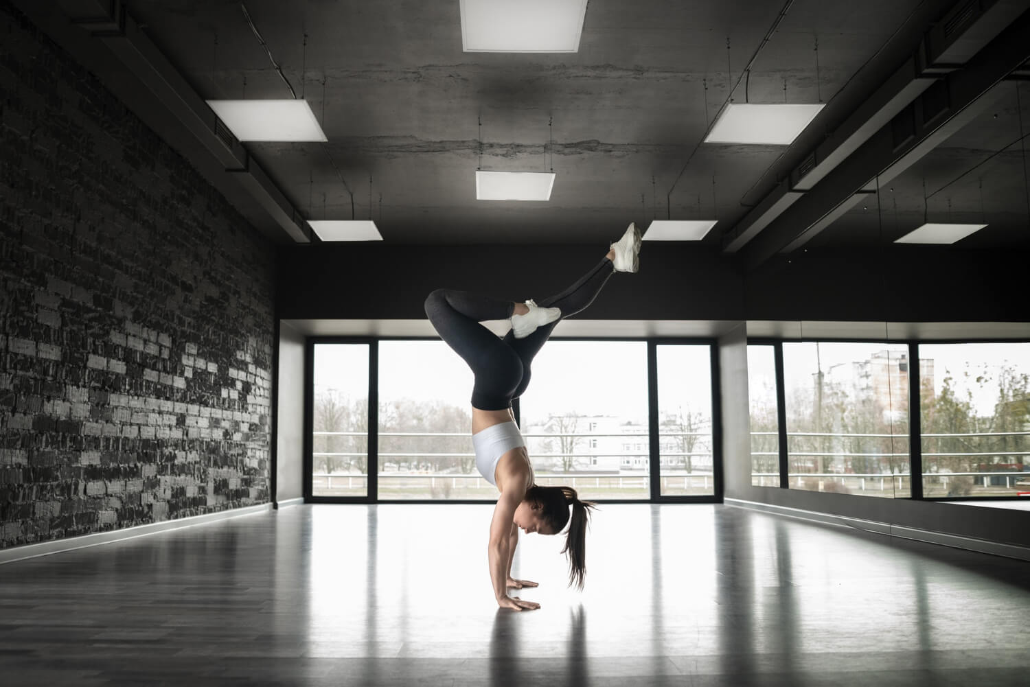 Young white Lady in a Dance Studio doing a hand stand - Dance Studios Houston, Texas.